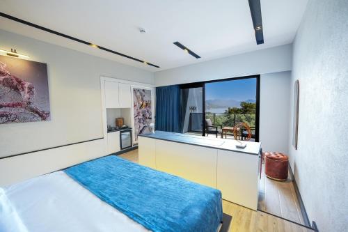 a bedroom with a bed and a kitchen with a window at Ramitos Boutique Hotel in Marmaris