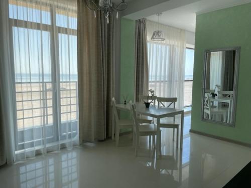 a dining room with a table and a view of the ocean at Beach Rooms Roberta in Mamaia