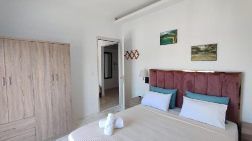 a bedroom with a large bed with blue and white pillows at Wave Sound Apartments - Village View in Skala Marion