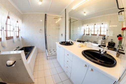a bathroom with two sinks and a large mirror at Maclear Manor in Maclear