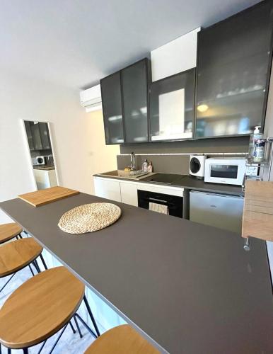 a kitchen with a table and some chairs in it at T2 à 50m de la mer in Bormes-les-Mimosas
