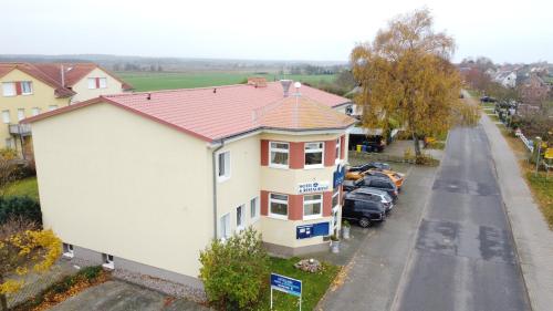 una casa blanca con techo rojo junto a una calle en Ostseeperle Börgerende en Börgerende-Rethwisch