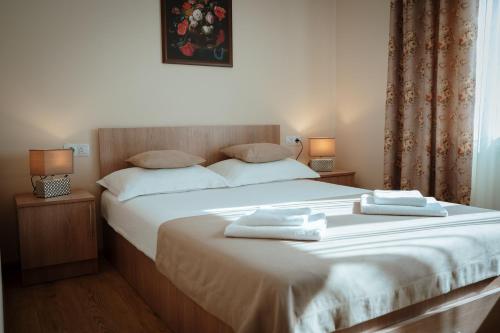 a bedroom with a bed with two towels on it at Vila Rodica Transalpina in Şugag