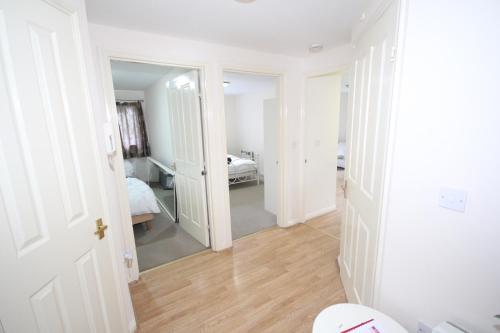 Habitación con pasillo, cama y espejo. en Colham Place, en Hillingdon