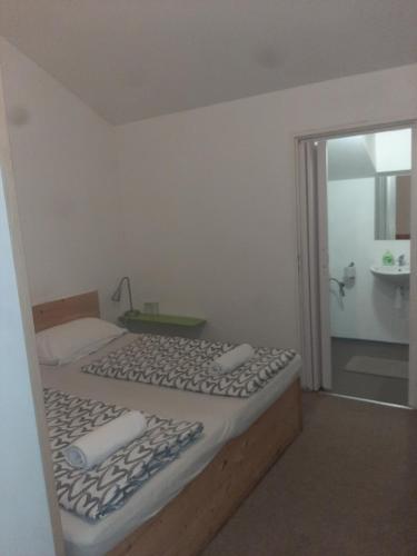 a small bedroom with a bed and a bathroom at Ubytování Šámalka in Brno