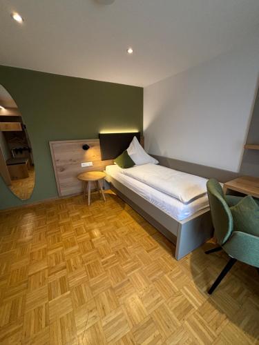 a small bedroom with a bed and a chair at Landgasthaus zur Linde in Bühl