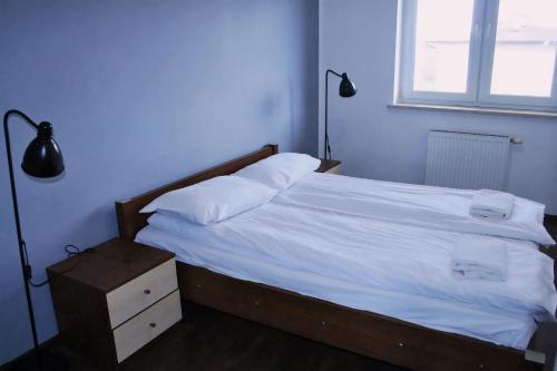 um quarto com uma cama com lençóis brancos e uma janela em Apartament Rodzinny em Bydgoszcz