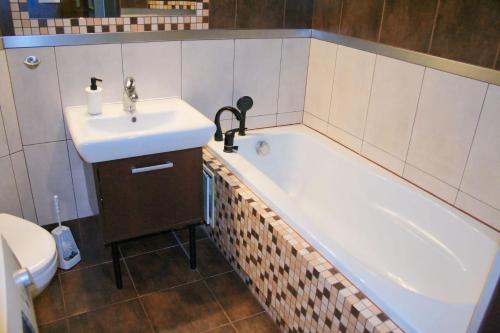 uma casa de banho com um lavatório e uma banheira em Apartament Rodzinny em Bydgoszcz