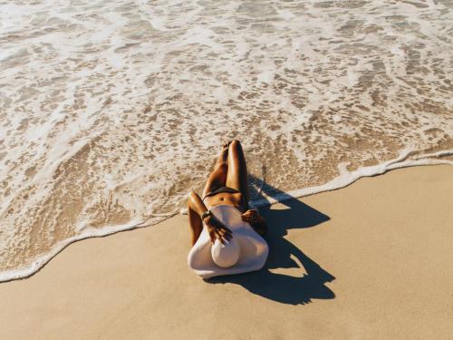 une femme qui se couche sur le sable sur la plage dans l'établissement VACATION MARBELLA I Villa Nadal, Private Pool, Lush Garden, Best Beaches at Your Doorstep, à Marbella