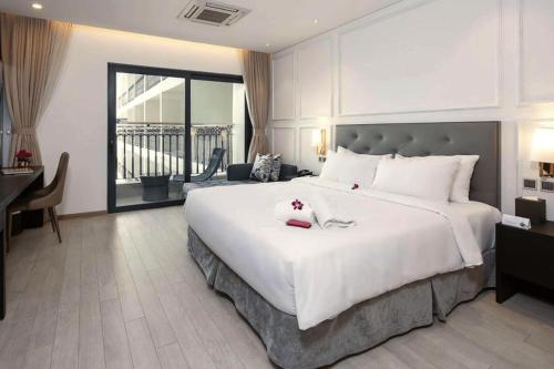 um grande quarto com uma grande cama branca e uma secretária em Goldenbay Danang 1 Bedroom Apartment em Da Nang