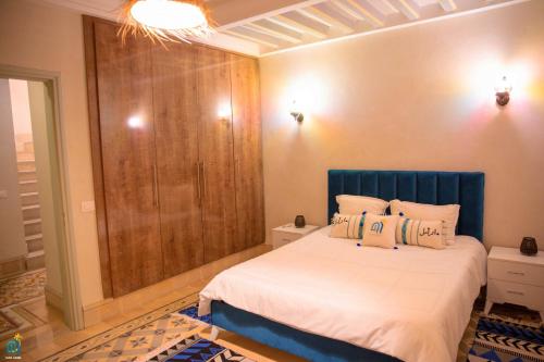 - une chambre avec un lit et un placard en bois dans l'établissement DAR AMEL, à Houmt Souk
