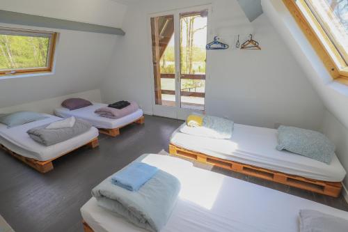 una camera con tre letti e una finestra di Crazy Villa Ecottay 61 - Heated pool & sauna - 2h from Paris - 30p a La Loupe