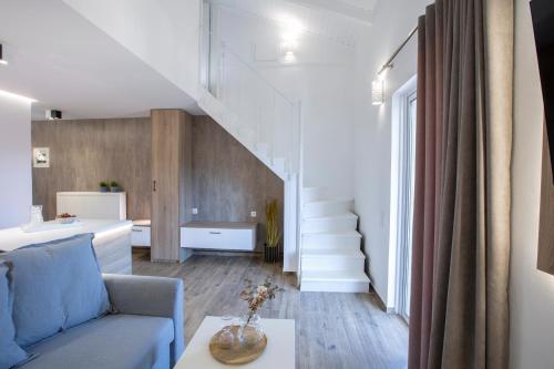 a living room with a blue couch and stairs at Skyview Suites in Lefkada Town