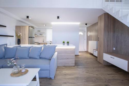 a living room with a blue couch and a kitchen at Skyview Suites in Lefkada Town