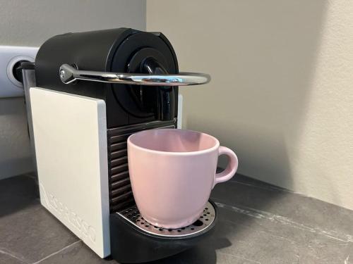 a coffee maker with a cup on top of it at Antica Stazione in Guebwiller