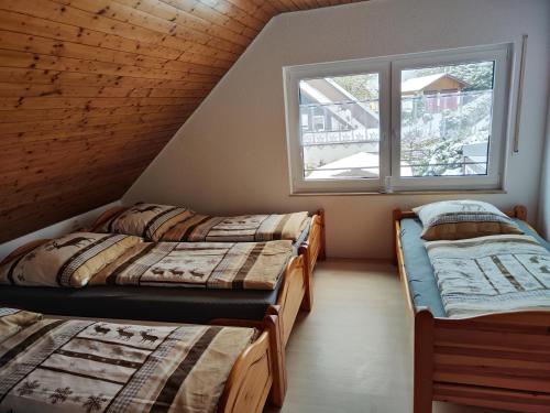 three beds in a room with a window at Ferienhaus Hermann in Schonwald im Schwarzwald