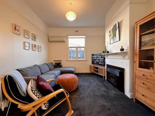 a living room with a couch and a fireplace at Enchanting Vintage House at South Hobart in Hobart