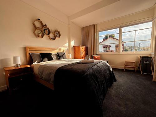 a bedroom with a bed and a large window at Enchanting Vintage House at South Hobart in Hobart
