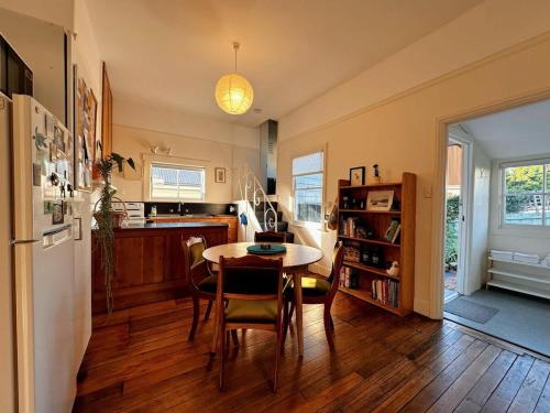a kitchen with a table and chairs and a refrigerator at Enchanting Vintage House at South Hobart in Hobart