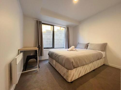 a bedroom with a bed with a desk and a window at 3 bedroom Apartment at Kingston in Kingston