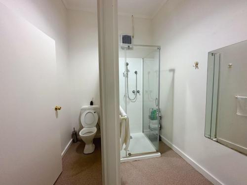 a bathroom with a toilet and a glass shower at Central Collins Residence at Inner City in Hobart