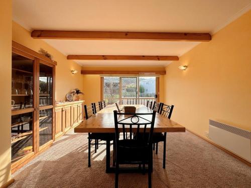 a dining room with a wooden table and chairs at Tranquil Sunlit Retreat close to CBD and Airport in Howrah