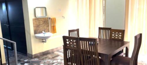 a dining room with a table and a sink at Uncle Paul's Mansion in Cochin