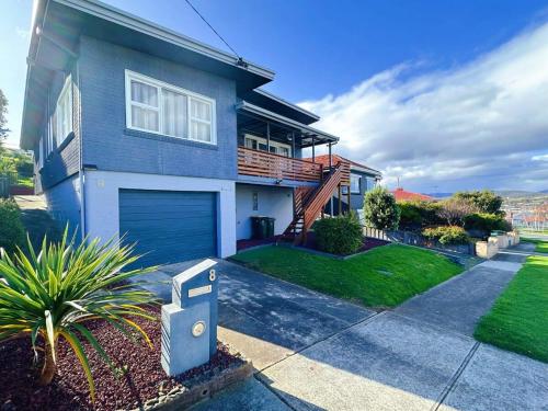 a blue house with a garage at Fonton Blue Holiday Home close to City and Airport in Moonah