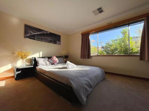 a bedroom with a bed and a large window at Rose Retreat with Water Front view at Montrose in Rosetta