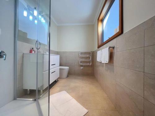 a bathroom with a glass shower and a toilet at Rose Retreat with Water Front view at Montrose in Rosetta