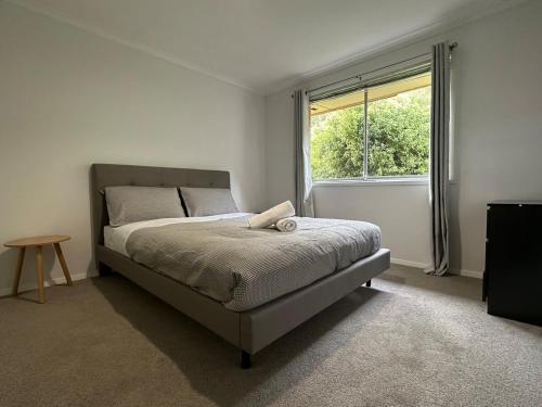 a bedroom with a bed and a large window at Skyline Serenity House - Close to city and airport in Lindisfarne