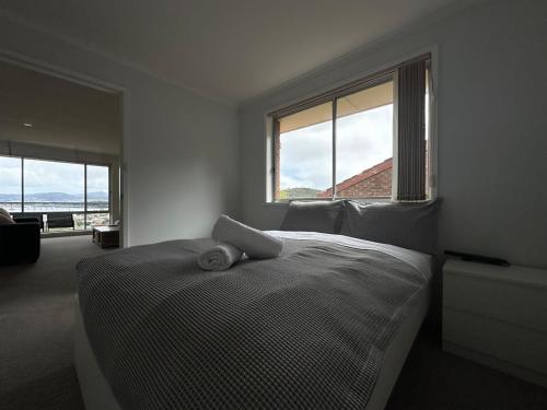 a bedroom with a bed and a large window at Skyline Serenity House - Close to city and airport in Lindisfarne
