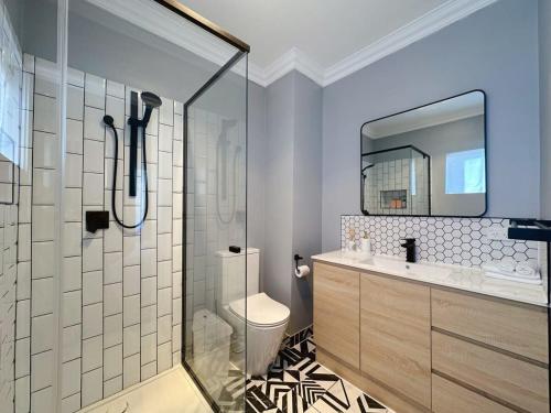 a bathroom with a shower and a toilet and a sink at SandyBay Garden Hideaway in Sandy Bay