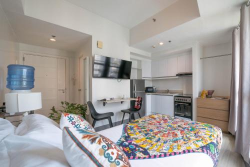 a living room with a couch and a kitchen at KL Tower Makati Apartments by PH Staycation in Manila
