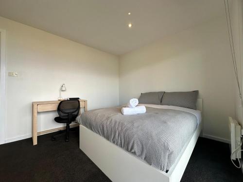 a small bedroom with a bed and a desk at Skyline Serenity Lower - Close to city and airport in Lindisfarne