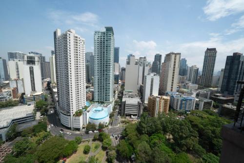 a city skyline with tall buildings and trees at KL Tower Makati Apartments by PH Staycation in Manila