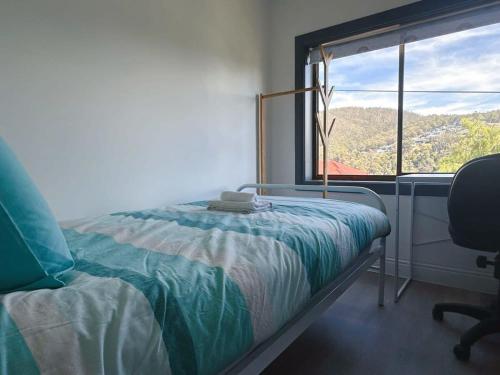a bedroom with a bed and a desk and a window at Wellesley Mountain View Getaway near City in Hobart