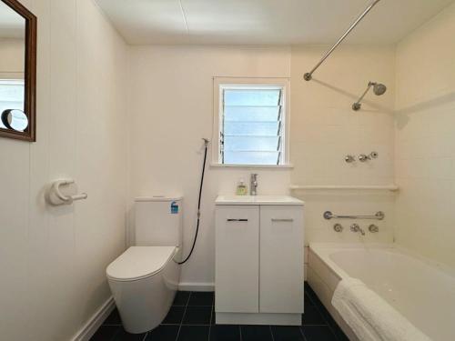 a white bathroom with a toilet and a bath tub at Wellesley Mountain View Getaway near City in Hobart