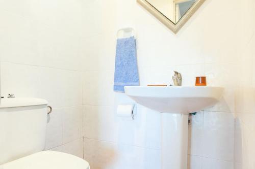 a white bathroom with a sink and a toilet at House in Rodalquilar valley in Rodalquilar
