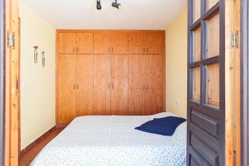 1 dormitorio con 1 cama y armarios de madera en House in Rodalquilar valley en Rodalquilar