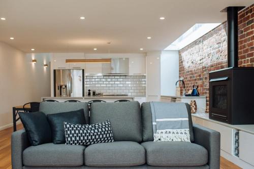 a living room with a couch and a kitchen at SENSATIONAL Renovated Cottage in Beautiful Seddon in Seddon