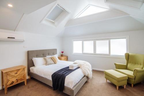 una camera da letto con un letto e una sedia verde di SENSATIONAL Renovated Cottage in Beautiful Seddon a Seddon