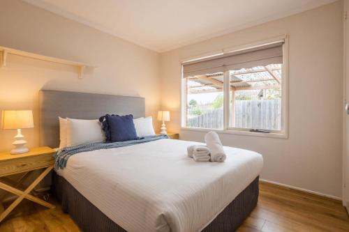 Un dormitorio con una cama grande y una ventana en Cozy Family Friendly Werribee Home, en Werribee