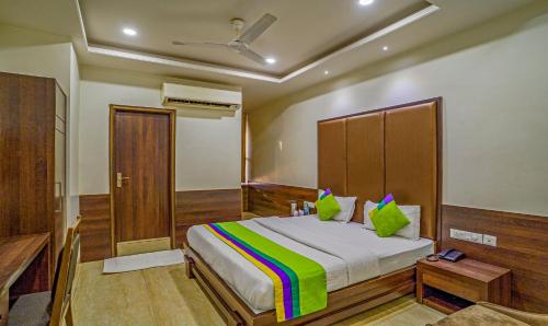 a bedroom with a large bed with green pillows at Treebo Bliss in Jaipur