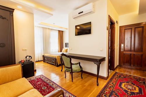 a living room with a desk and a bed at WOO Town Suites in Antalya