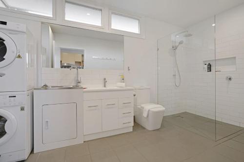 a white bathroom with a sink and a washing machine at The Starfish Cottage - 250m to bay beach in Rye