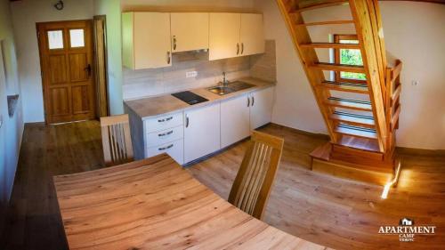 uma cozinha com uma mesa e uma escada numa casa em Brunarica Vrhovc em Železniki