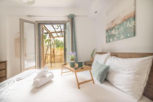 ein Schlafzimmer mit einem Bett und einem Tisch mit Handtüchern darauf in der Unterkunft Citrea Stylish House with Garden near Beach in Heraklion
