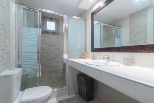 bagno con servizi igienici, lavandino e specchio di Citrea Stylish House with Garden near Beach a Heraklion