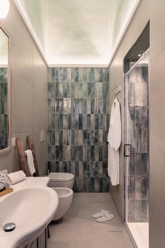 un bagno con lavandino, WC e doccia di Auriga Luxury Flat a Modugno